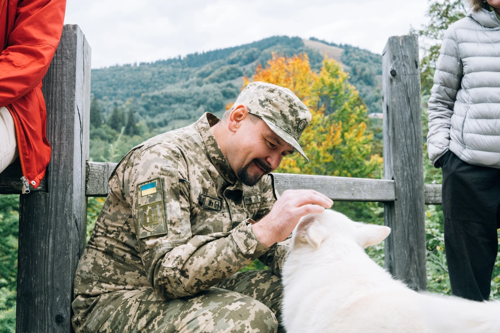 A participant stroking a white dog outdoors