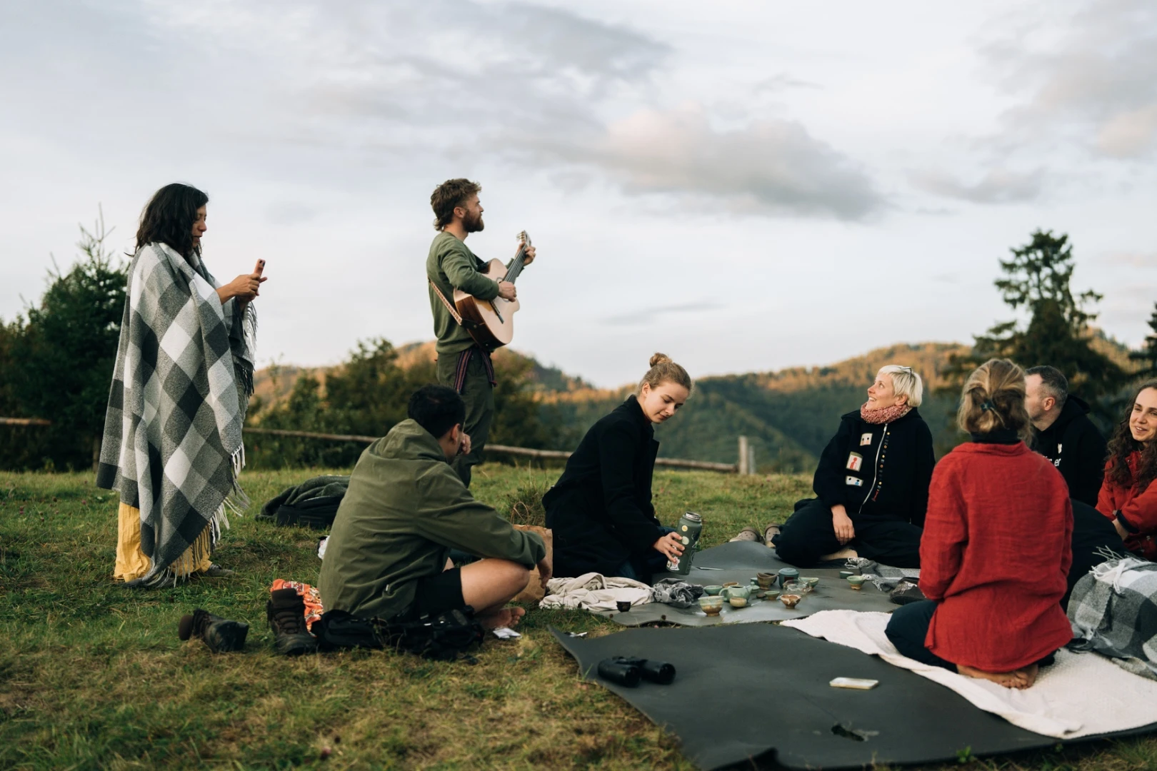 A gathering with tea and music on a hillside