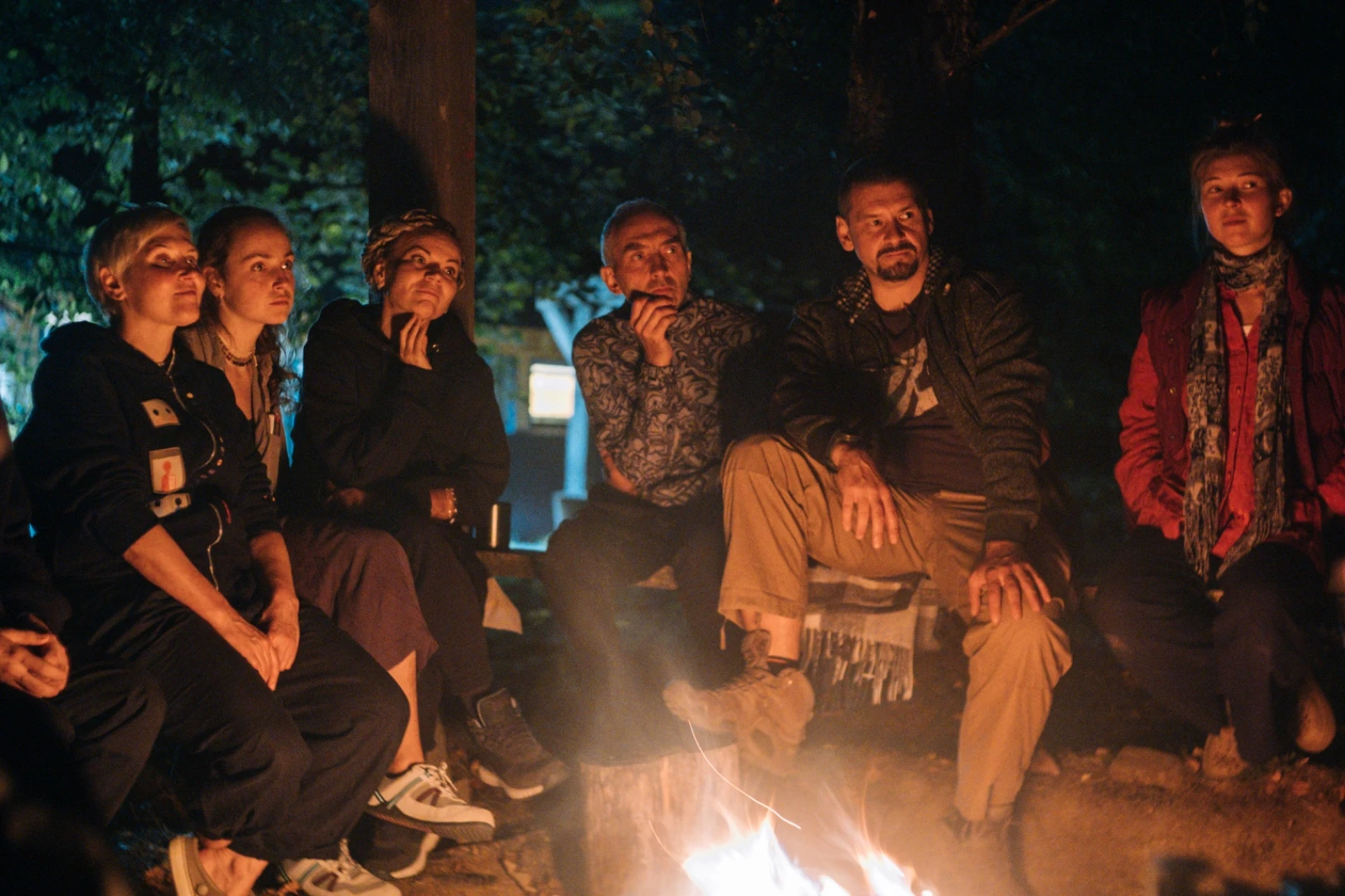 People listening beside a campfire